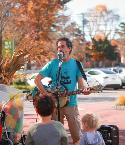 Man singing and playing guitar in front of children