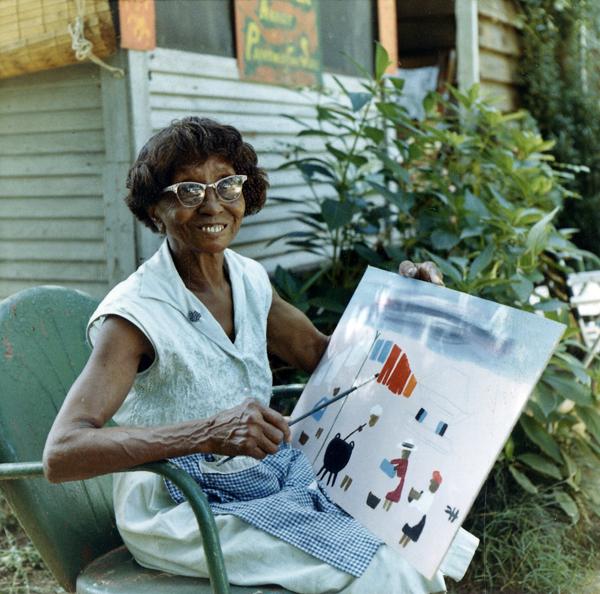 Photo of Clementine Hunter with one of her paintings